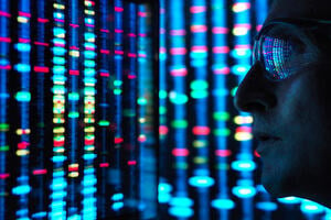 Genetic Research, a closeup of a male scientist viewing DNA information on a wide computer screen screens with blue, red , yellow and green colour representing different data