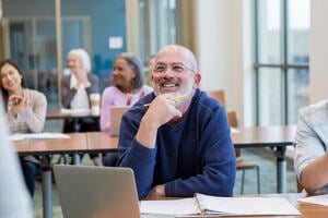 Diverse group of students have fun during their adult creative writing class at the local college.