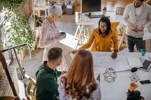 Team of researchers collaborating around a plan on a table