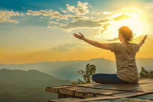 Healthy woman lifestyle balanced practicing meditate and zen energy yoga outdoors on the bridge in morning the mountain nature. Healthy life Concept.