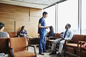 Health professional talking to autistic patient in waiting room 