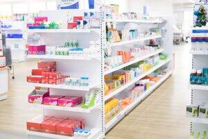 At the chemist, Medicines arranged in shelves, Pharmacy drugstore retail Interior blur abstract backbround with medicine and healthcare product on cabinet with ืneon light with vaccine.