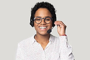 A woman of african ethnicity smiling and wearing a headset