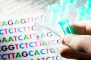 A hand holding a experiment tube with a DNA sequence in the background 