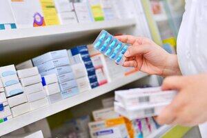 Pharmacists hold pill boxes and capsule packs for pharmacies.