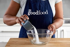 Chef pouring caster sugar in a bowl