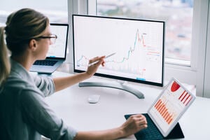 Woman looking at graphs and plots on a computer screen.