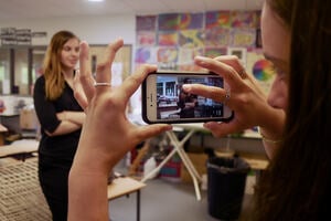 Woman operating a phone filming her friend 