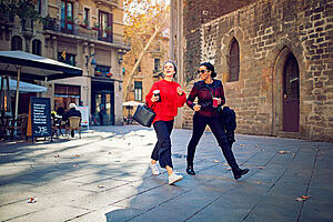 Two young women chatting and walking through the old streets of a Spanish town