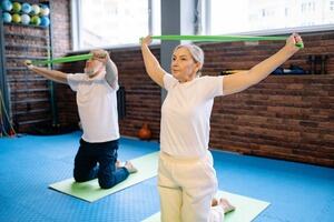 Two older people in an exercise class