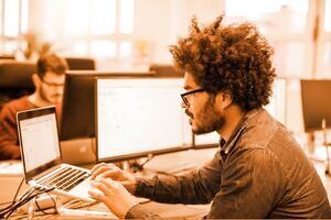 Male professional looking at his laptop in an office environment.